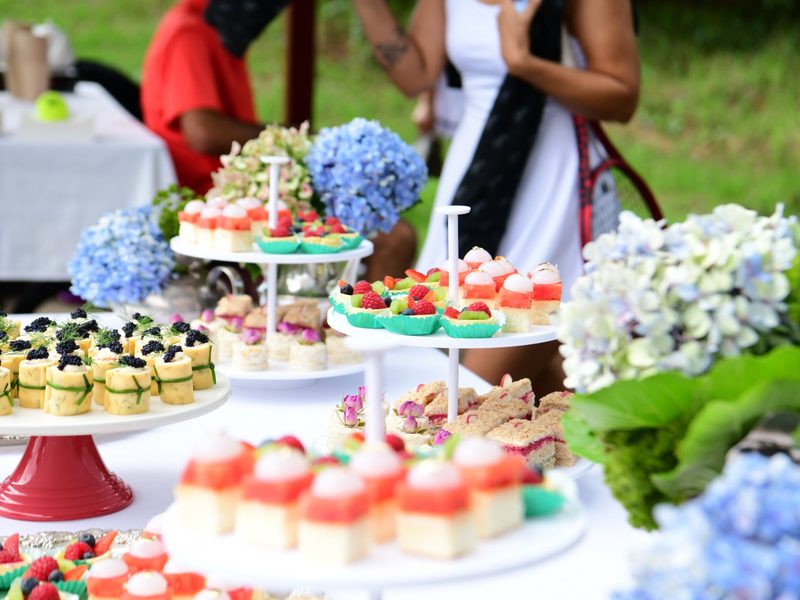 The high tea table laid out with sandwiches, pastries and hydrangeas