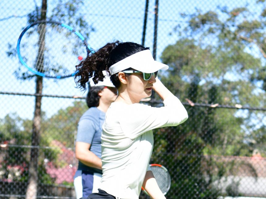 Adult player mid-rally in a group session